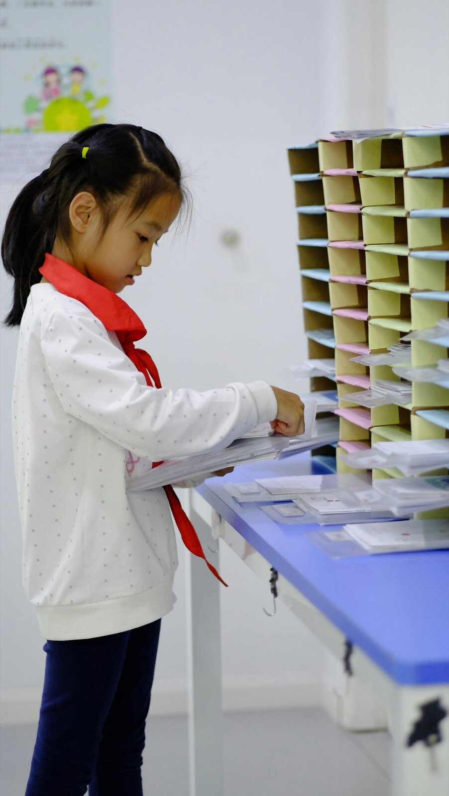 Child sorting and organizing papers at a table