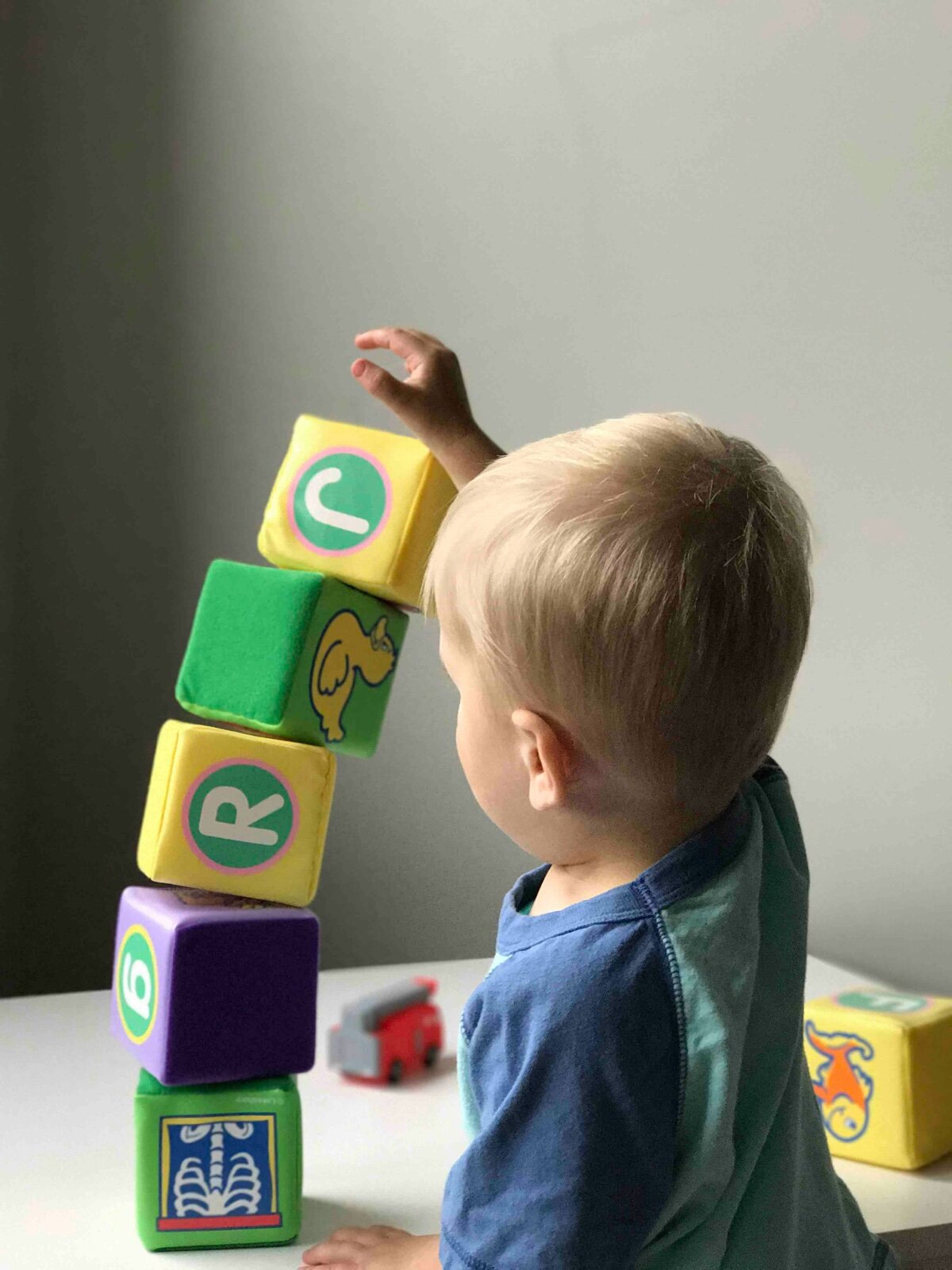 Child stacking letter blocks during a literacy activity